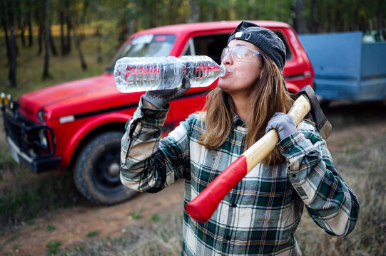Woman drinking water in forest while working