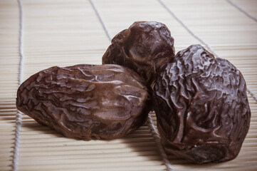 Big luxury dried date fruit on the bamboo mat, kurma ramadan kareem concept, close up.