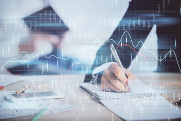 Double exposure of forex chart drawing over people taking notes background. Concept of financial analysis