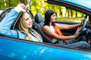 Close up of women drive convertible car. Little holiday trip of friends