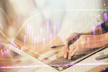 Double exposure of woman hands typing on computer and forex chart hologram drawing. Stock market...