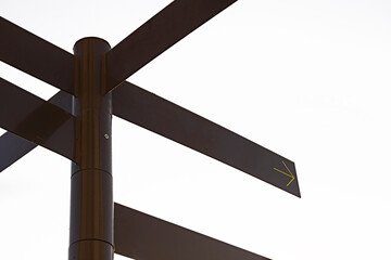 Dark coloured multidirectional signpost with applied arrow sign , isolated on white