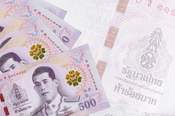 500 Thai baht bills lies in stack on background of big semi-transparent banknote. Abstract business...