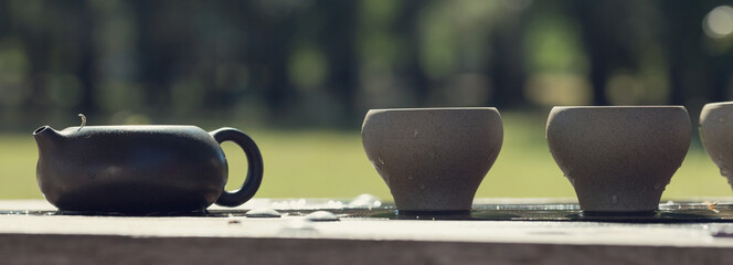 Chinese tea ceremony. Ceramic teapot made of clay and bowls on a wooden background.