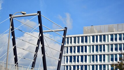 Naklejka premium Blue curtain wall made of toned glass and steel constructions under blue sky. A fragment of a building.