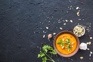 Delicious healthy pumpkin soup, herbs, and ingredients for the dish. Creative atmospheric decoration