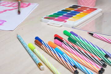Fototapeta premium felt-tip pens, watercolors and a drawing of a small child