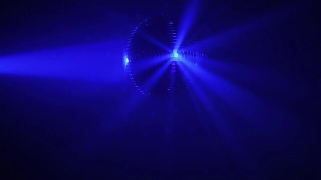 pumpkin disco ball with blue rays in fog at Halloween party, loop-ready blue background