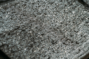 Worn car brake pad surface as abstract grey scratched background.