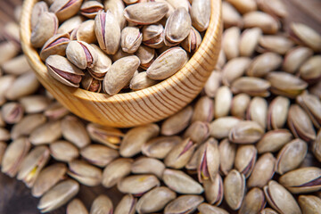 Pistachios in a Cup on a wooden background.  Place for text. Nuts close up