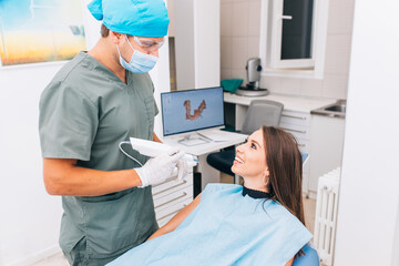 The dentist scans the patient's teeth with a 3d scanner.