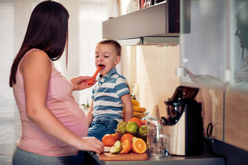 Family make fresh orange juice in the kitchen
