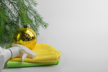 a bottle of household chemicals is lying on rags under the Christmas tree. Christmas cleaning