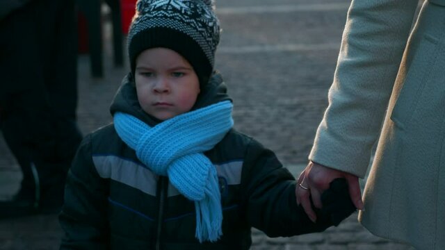 Mother with Child at Christmas Market Walking and Looking Around. Winter Holidays. Evening City Street. 2x Slow motion 60 fps 4K