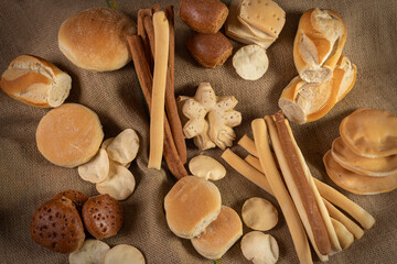 
production of different bakery breads, common bread, black bread, breadsticks, fat bread, on rustic burlap cloth