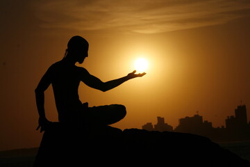Obraz na płótnie Canvas silueta mística meditación con el sol