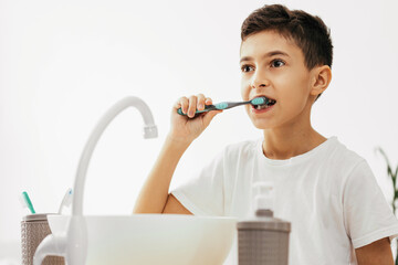 10 year old boy brushing his teeth in the bathroom