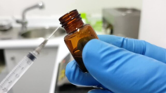Syringe and vaccine bottle in medical setting. Immunisation concept 
