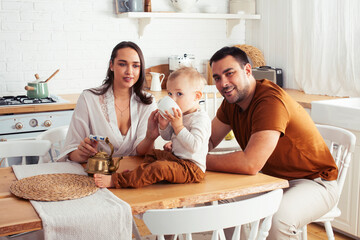 young family with little cute son on kitchen in morning happy smiling, lifestyle people concept