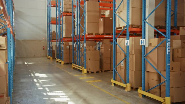 Gigantic Sunny Retail Warehouse full of Shelves with Goods in Cardboard Boxes. Logistics and Distribution Storehouse Center for further Product Delivery Packages. Descending Semi Side Camera View