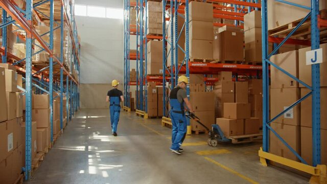 Retail Delivery Warehouse full of Shelves with Goods in Cardboard Boxes, Workers Scan and Sort Packages, Move Inventory with Pallet Trucks and Forklifts. Product Distribution Logistics Center. Dolly
