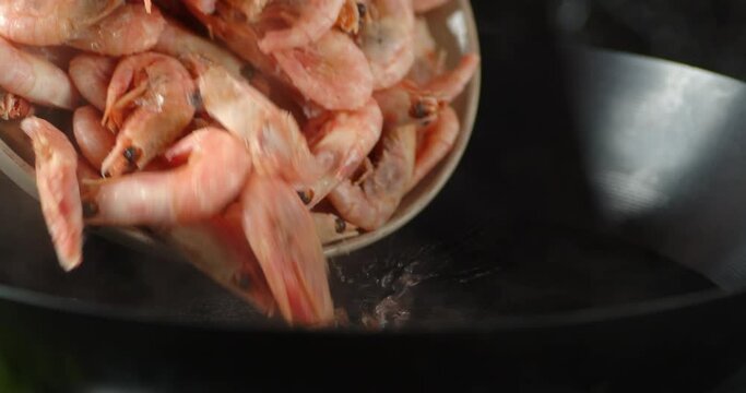 Shrimps are put in boiling water in a saucepan. 