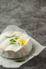 white blue cheese camembert with honey on gray background.