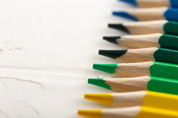 colored pencils in row on a white background