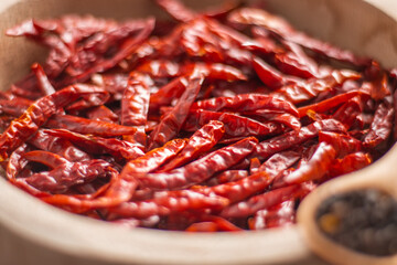 Tazón de madera con chiles secos y especias en detalle en mesa de madera