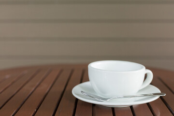 Selective focus of white coffee cup on the table in cafe  blurred background