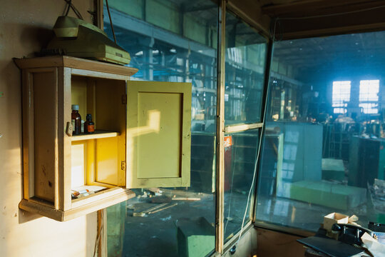 An old first aid kit and an old phone on watch an abandoned old industrial plant.