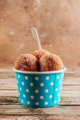 Cottage cheese donuts in a light blue paper cup