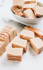 Raw vegan peanut butter fudge on a white marble background.