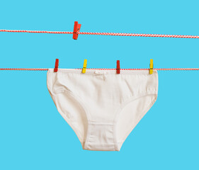 Two clotheslines and women's panties on a blue background.