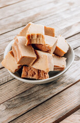 Raw vegan peanut butter fudge on a rustic wooden background.
