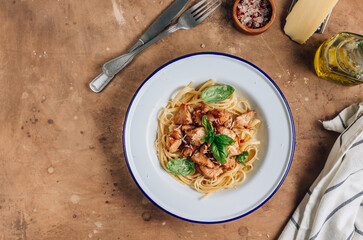 Spaghetti with chicken and basil in an enamel plate