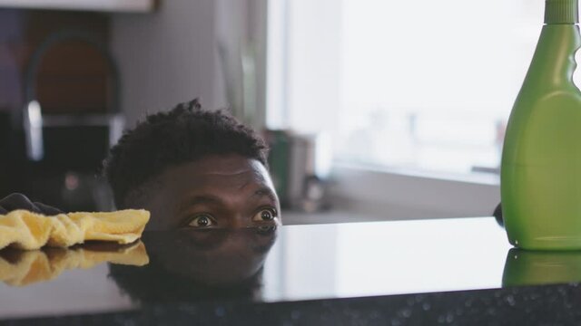 Black man cleaning kitchen. Surface reflects his face . High quality 4k footage