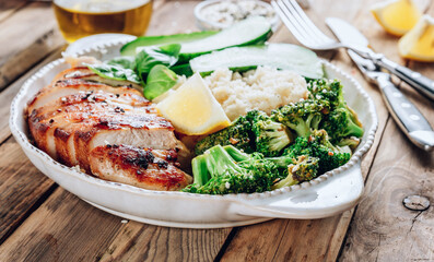 Keto lunch bowl. Grilled chicken with cauliflower rice, broccoli and cucumber.