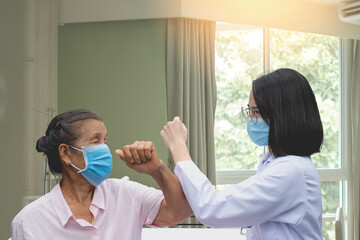 Doctor and senior patient elbow bump after a consultation about healthcare, new normal greeting after the coronavirus outbreak, health medical checkup concept