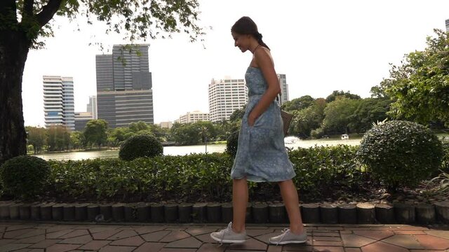 Beautiful woman walking in the city park, slow motion