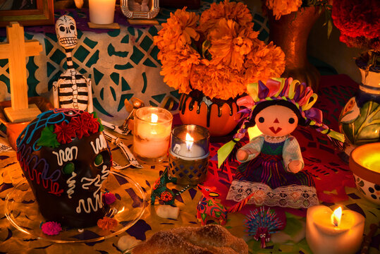 Mexican day of the dead altar at night in dim candlelight