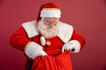 Santa Claus looking inside the gift bag. Christmas is coming. Merry Christmas.