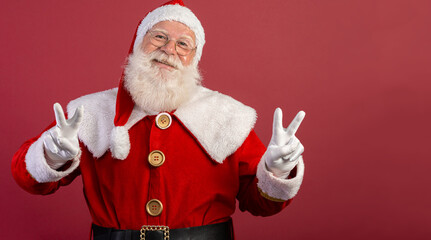 Fototapeta na wymiar Santa Claus looking at the camera. Christmas is coming. Merry Christmas. Peace. V sign.