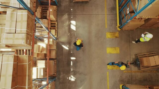 Top-Down View: In Warehouse People Working, Forklift Truck Operator Lifts Pallet with Cardboard Box. Logistics, Distribution Center with Products Ready for Global Shipment, Customer Delivery