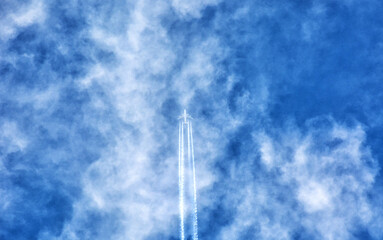 plane flying through blue sky with clouds