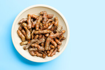 Turmeric roots on blue background.