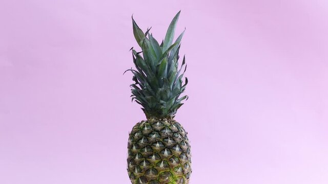 Fast and slowly pineapple rotating on pastel pink theme