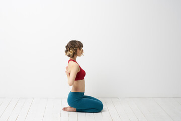 the girl is engaged in yoga on a light background Red T-shirt gesticulating with his hands
