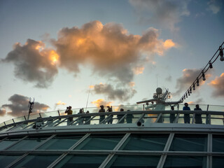 Silhouette of people at railing on luxury cruiseship or cruise ship liner watching sunset, sunrise...