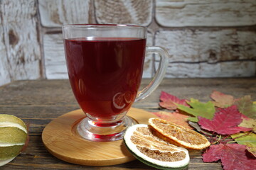 Hot fruit tea with lemon on a wooden background. Selective focus.Still life, food and drink, seasonal  concept.

